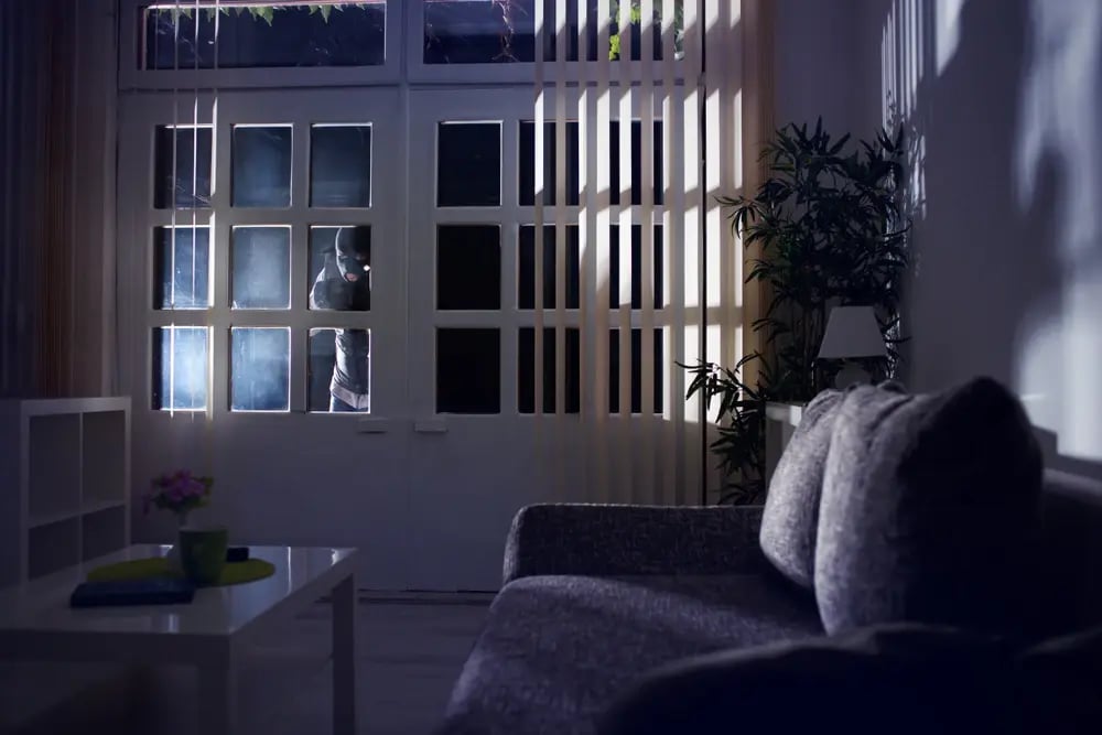 persona intentando realizar un robo a casa por la noche
