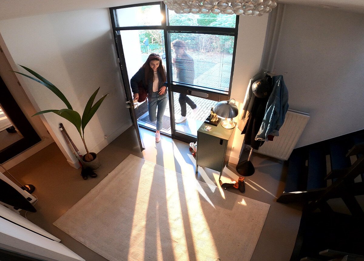 mujer entrando en casa con alarma para bajo conectada