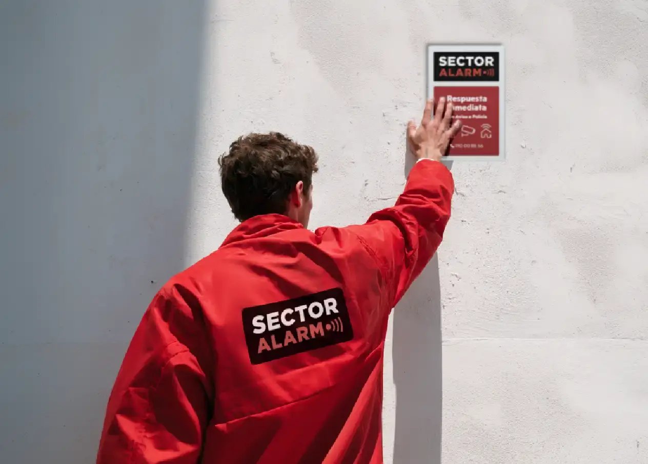 Personal de sector alarm montando alarma en nave industrial