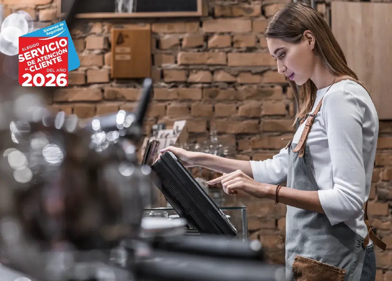mujer trabajando en cafeteria con alarmas para locales comerciales
